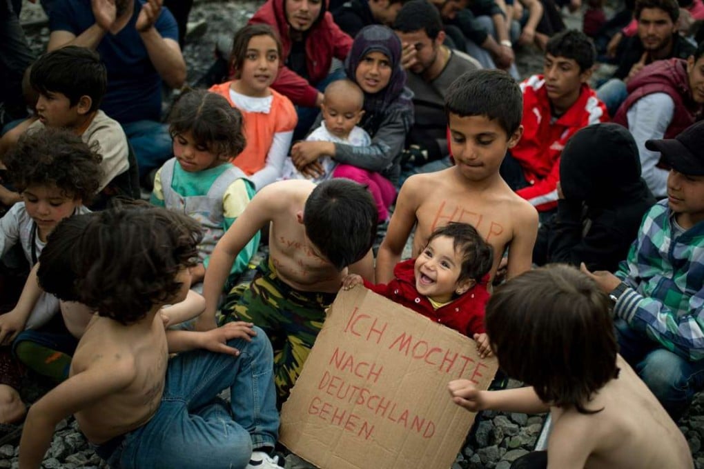A child holds a placard reading “I want to go to Germany” in German during a protest held by migrants calling for the reopening of the borders at a makeshift camp at the Greek-Macedonian border. Germany is the most desired final destination in Europe for those fleeing war. Photo: AFP