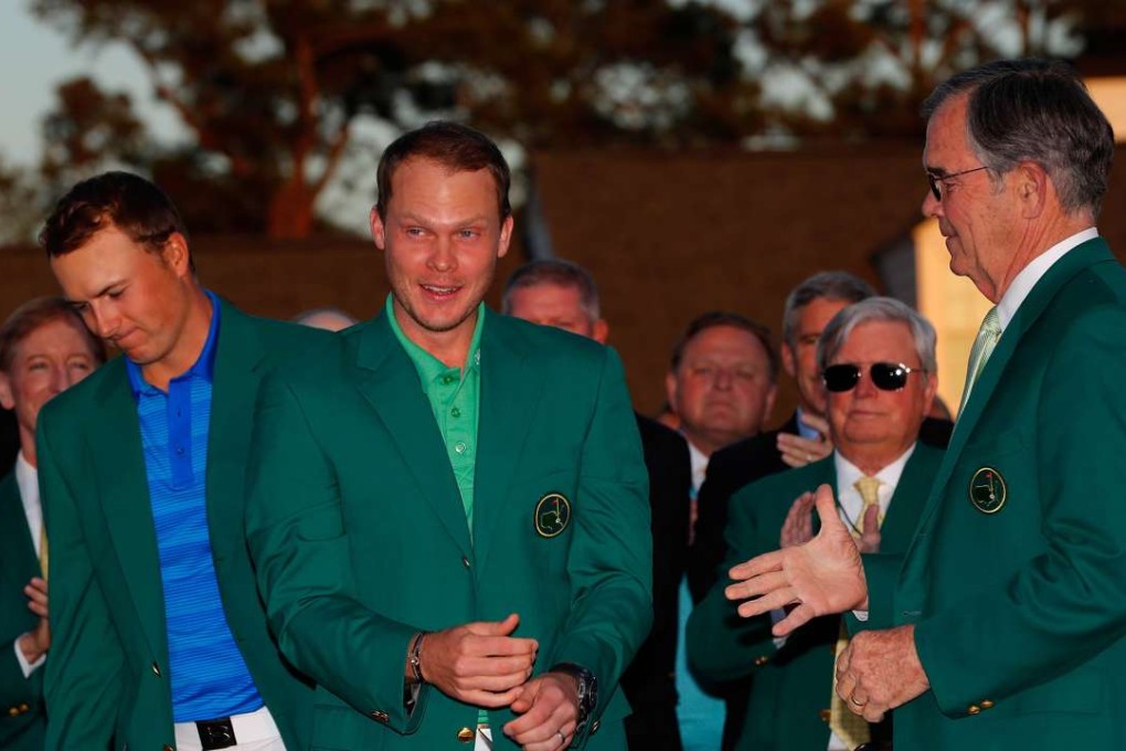 A visibly dejected Jordan Spieth presents Masters champions Danny Willett with the iconic green jacket. Photo: AFP