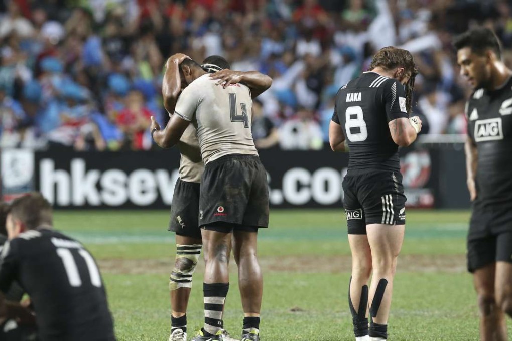 Fijians celebrates as New Zealand players react with disappointment after losing the Cup final at the Hong Kong Sevens On Sunday. Photo: K. Y. Cheng