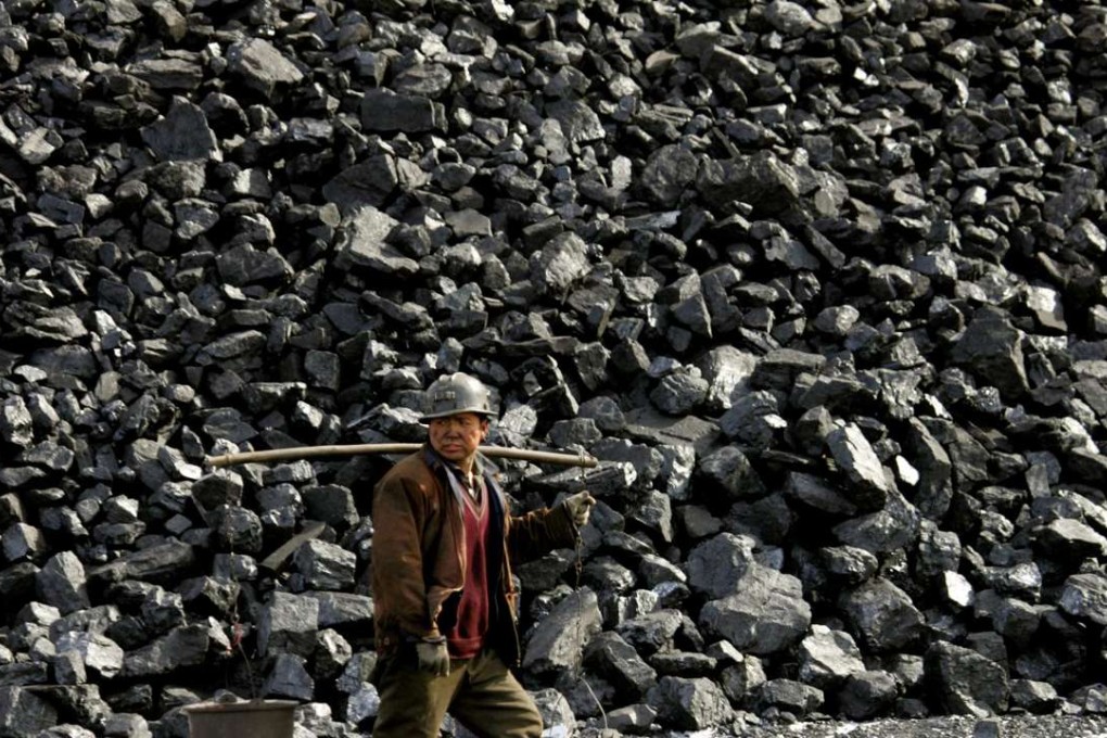 A Chinese miner walks past a coal heap outside a mine near Datong in this February 22, 2005 file photo. Chinese coal miners are raising spot prices in a domestic market struggling to recover from seven-year lows, desperate for an edge in annual negotiations to supply power plants, key buyers in the world's biggest consumer of coal, industry sources say. REUTERS/Reinhard Krause/Files (CHINA - Tags: BUSINESS ENERGY)