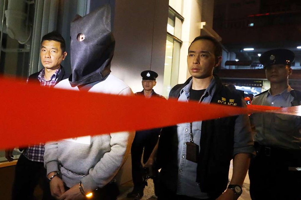 A suspect held over a murder in Tsuen Wan was escorted back to the crime scene for a reconstruction. Photo: Felix Wong