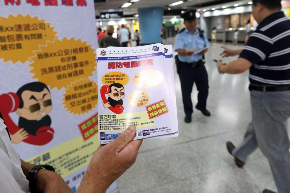 Police officers from Crime Prevention Bureau give out leaflets to alert citizen about phone scammers. Photo: SCMP Pictures