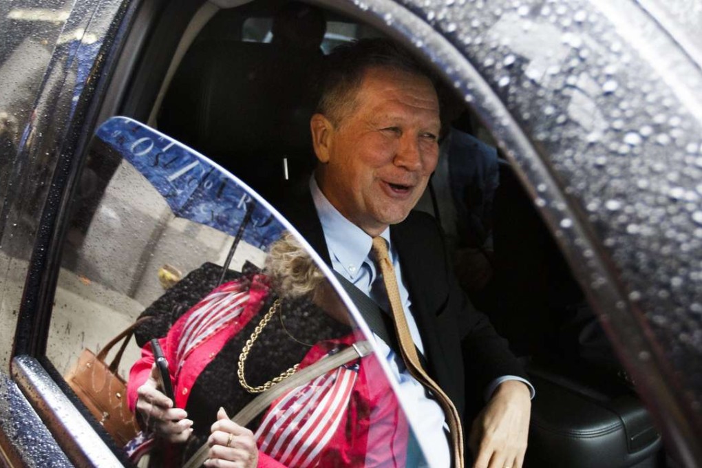 Republican presidential candidate Governor John Kasich of Ohio talks to reporters from his car after delivering a speech at the Women's National Republican Club in New York on Tuesday. Photo: EPA