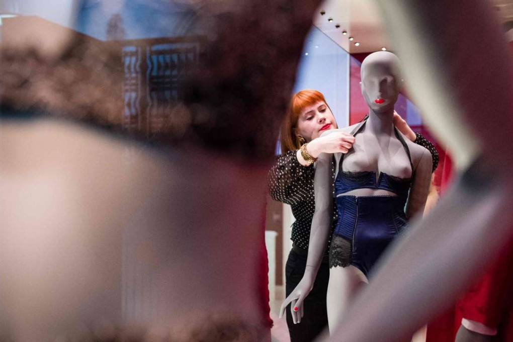 A gallery assistant adjusts a design included in the exhibition “Undressed: A Brief History of Underwear”at the V&A museum in London. Photo: AFP