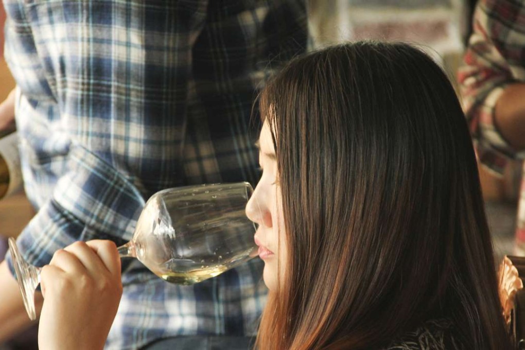A student tasting wine at a Wine in University event in China.