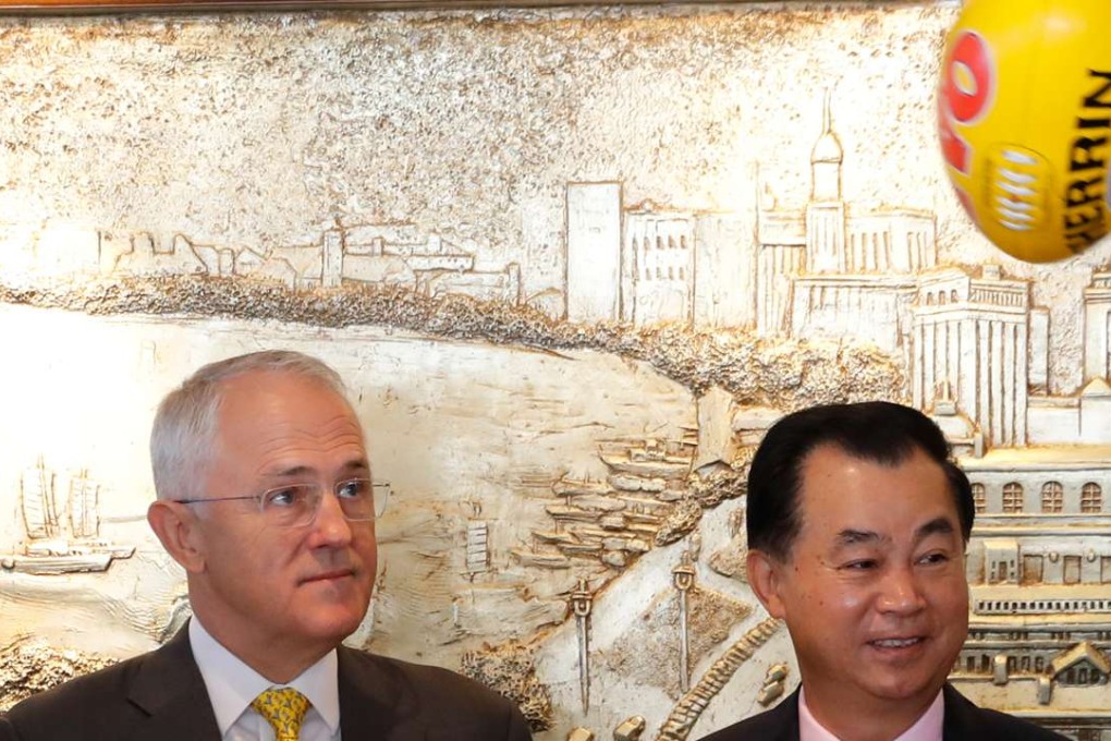Australian Prime Minister Malcolm Turnbull, left, watches a ball flying past Gui Guojie, general manager of Shanghai CRED Real Estate Stock, after a signing of the memorandum of understanding between the Port Adelaide Football Club, Australian Football League and Chinese sponsorship at a hotel in Shanghai, China on Thursday, April 14. Photo: AP
