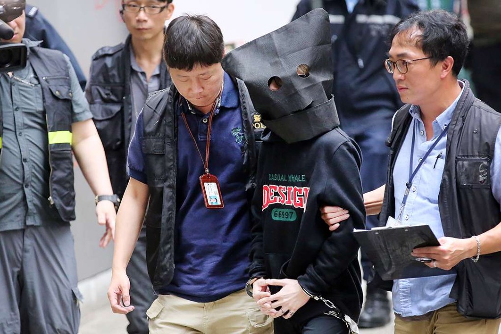 Tsang Cheung-yan, a suspect linked to the body-in-cement murder in a Tsuen Wan industrial building, is escorted back to the scene of the crime for a reconstruction. Photo: Edward Wong