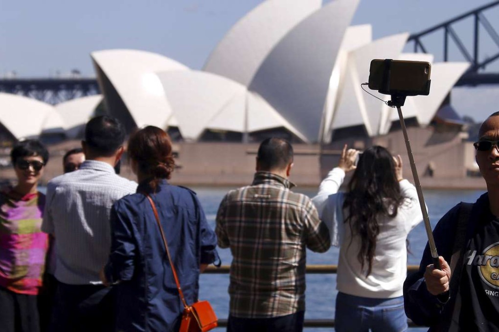 Chinese tourists take pictures in front of the Sydney Opera House in Sydney. Photo: Reuters