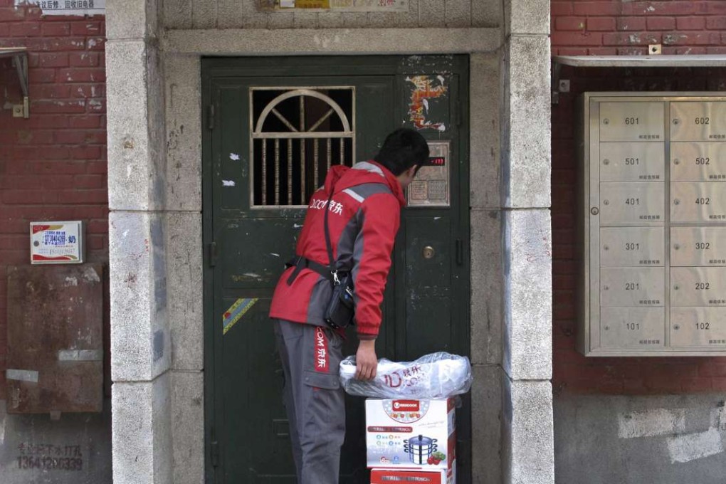 A courier with Jingdong, also known as JD.com, rings the bell of an apartment where he is making a delivery, in Beijing. Photo: Reuters