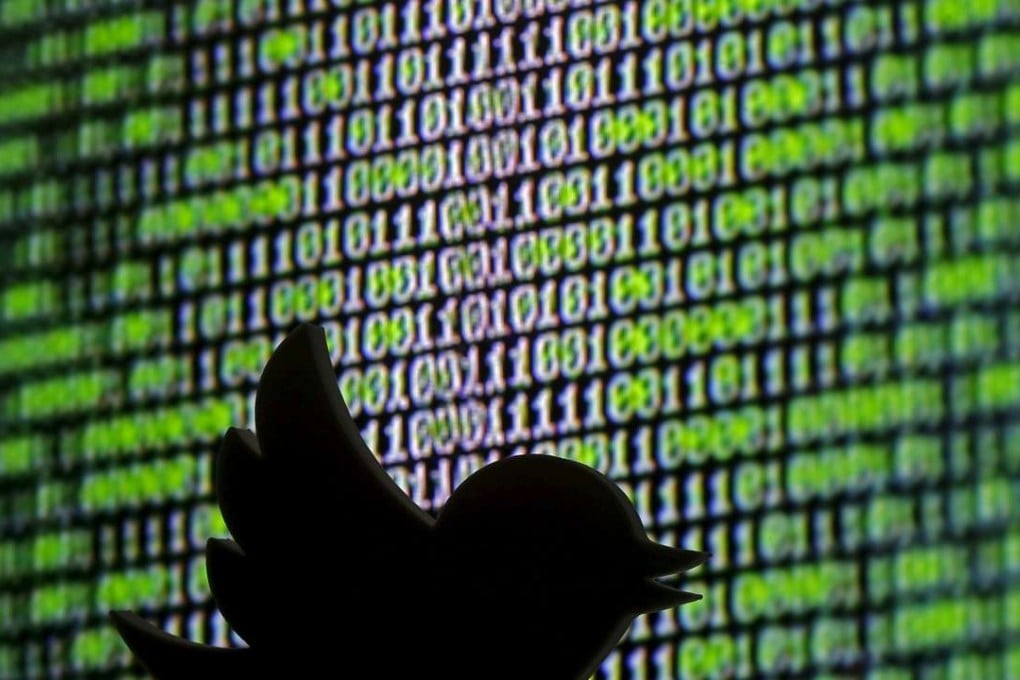 A 3D printed Twitter logo is seen in front of a displayed cyber code . Photo: Reuters