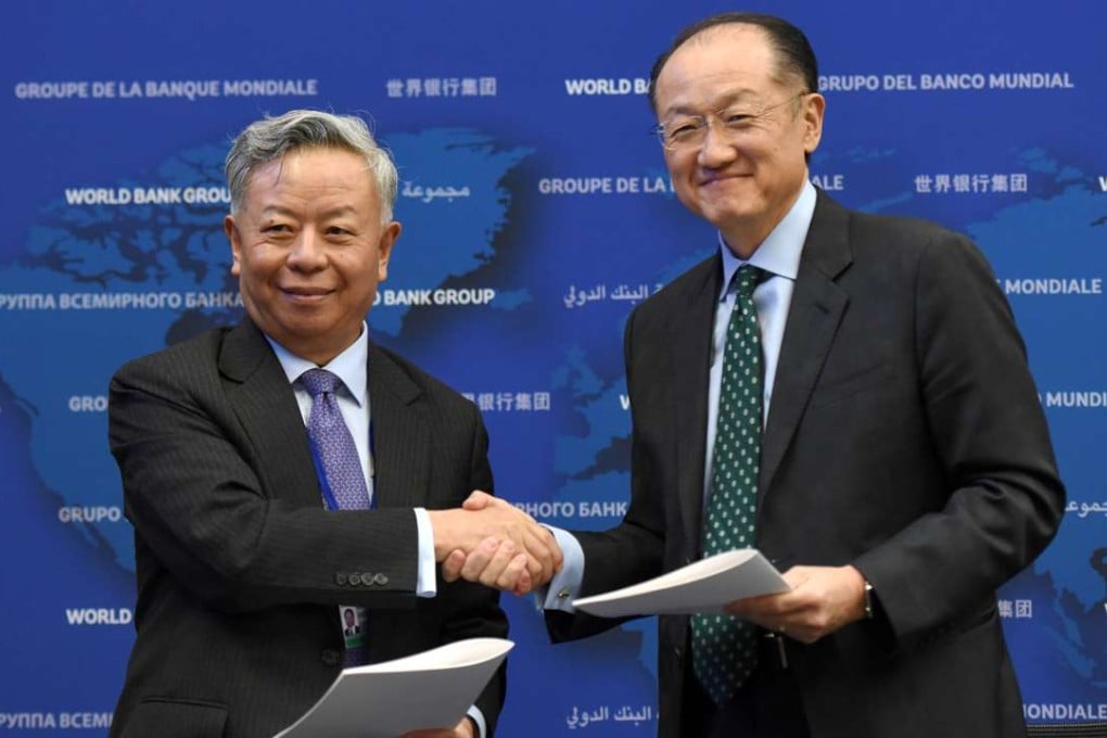 Jin Liqun, president of the Asian Infrastructure Investment Bank (left) and Jim Yong Kim, president of the World Bank, shakes hands on Wednesday after signing the first co-financing framework deal in Washington. Photo: Xinhua