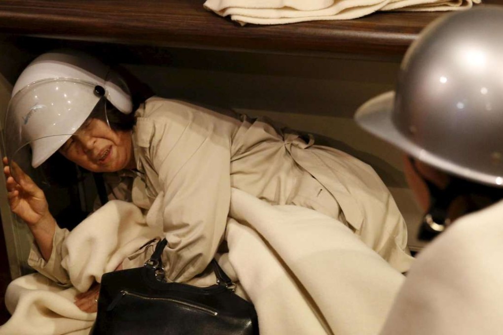 A woman takes shelter after another earthquake hit the area at a hotel in Kumamoto, southern Japan. Photo: Reuters/Kyodo