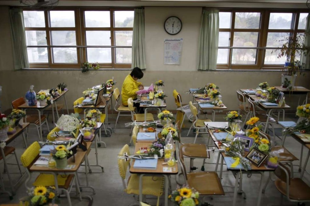 A mother of a victim who was on board the sunken ferry leaves a message on a desk used by her child at an empty classroom. Photo: Reuters
