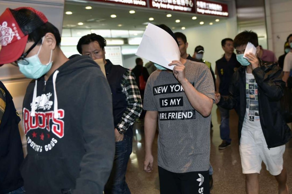 Taiwanese nationals arrive at Taoyuan International Airport in Taipei on Friday. Malaysia deported them back to Taiwan despite Beijing seeking to have them sent to the mainland. Photo: AFP
