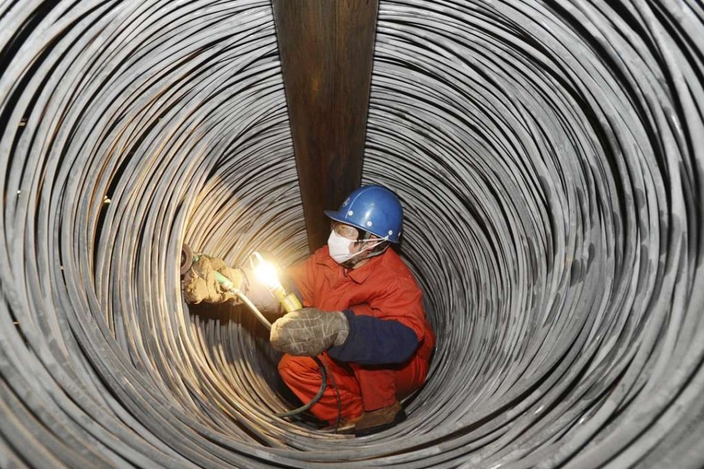 A Chinese worker checks steel rods at a plant in Dalian city, in northeast China's Liaoning province. Photo: Imaginechina
