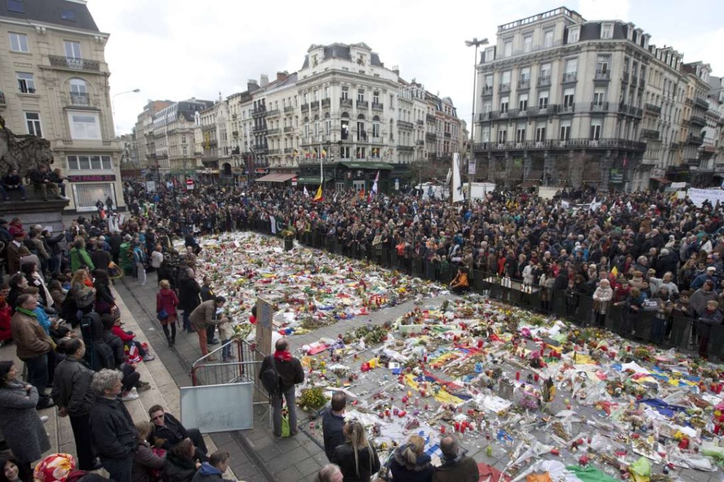 Marchers gather a floral memorial to victims of the Brussels attacks during a march against hate in Brussels on Sunday. Photo: AP