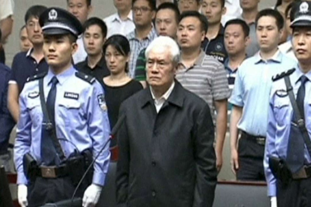 Zhou Yongkang, China's former domestic security chief, stands between his police escorts as he listens to his sentence for corruption and other crimes in a court in Tianjin in June. Photo: Reuters/China Central Television