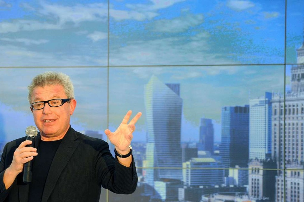 A file photo showing Polish born American architect Daniel Libeskind standing in front of a view of Warsaw's city centre, featuring his landmark luxury residential skyscraper design. Photo: AFP