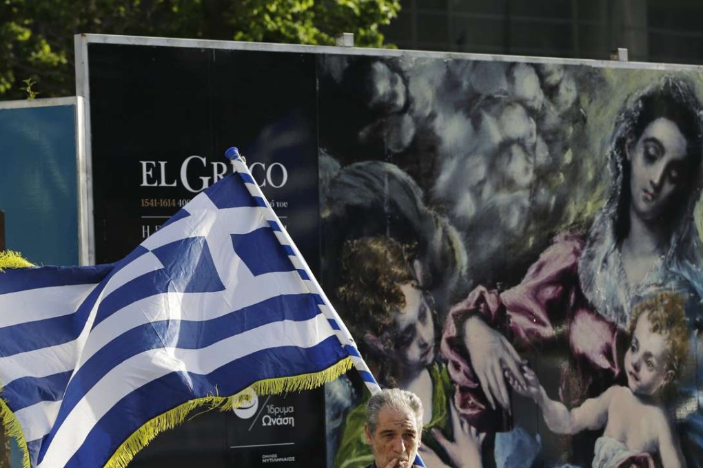 A demonstrator holding a Greek flag joins a protest against Greece's creditors in Athens on Monday, April 4, 2016, as Greece's government started new talks with bailout creditors amid a dispute over a wiretapped and leaked conversation between foreign officials involved in the Greek bailout negotiations. Photo: AP