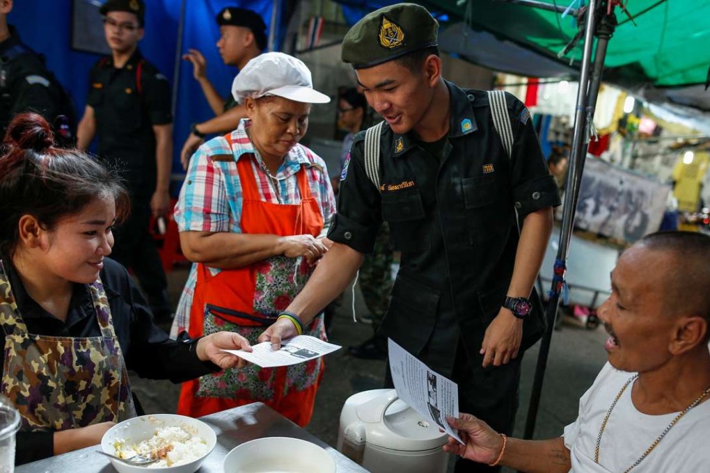 A student from the military's territorial defence programme offers brochures during a military campaign to tell people to vote in an August referendum on a new constitution in Bangkok, Thailand on April 19, 2016. Photo: Reuters