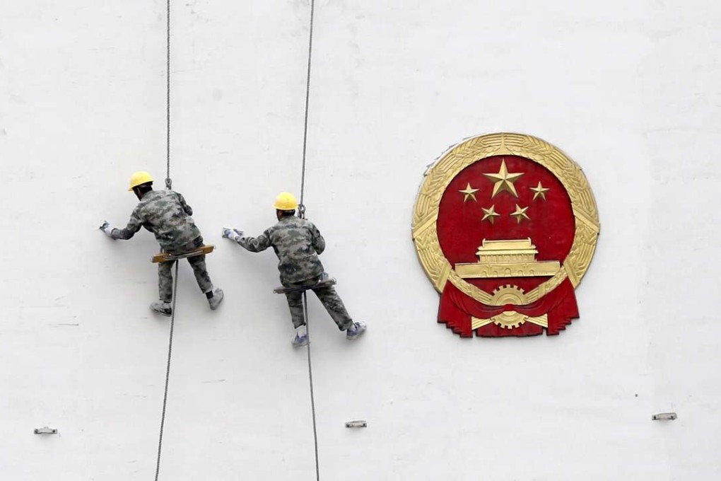 Workers paint a wall of a government building in Hangzhou, Zhejiang province. Photo: Reuters