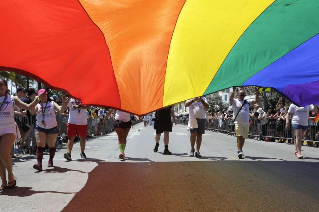 Participants carry a rainbow flag during a parade along Ocean Drive at Miami Beach Gay Pride on April 10. Photo: AP