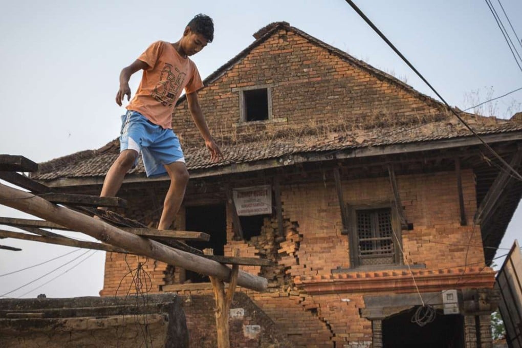 A boy works on the roof frame of a building next to the quake-damaged Bhairavi temple in the historic village of Nuwakot, Nepal, a year after the devastating April 2015 earthquake. Photos: Tessa Chan