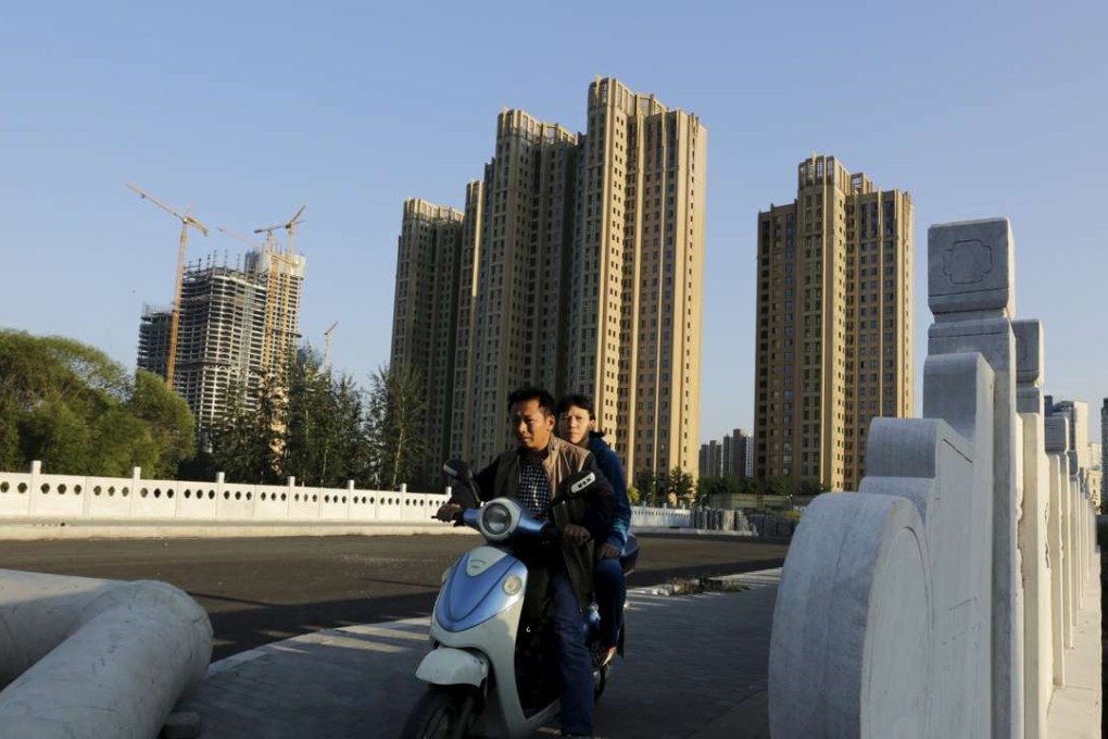 A couple drive near new apartment blocks in Beijing's Wangjing area on September 18, 2015. Photo: Reuters