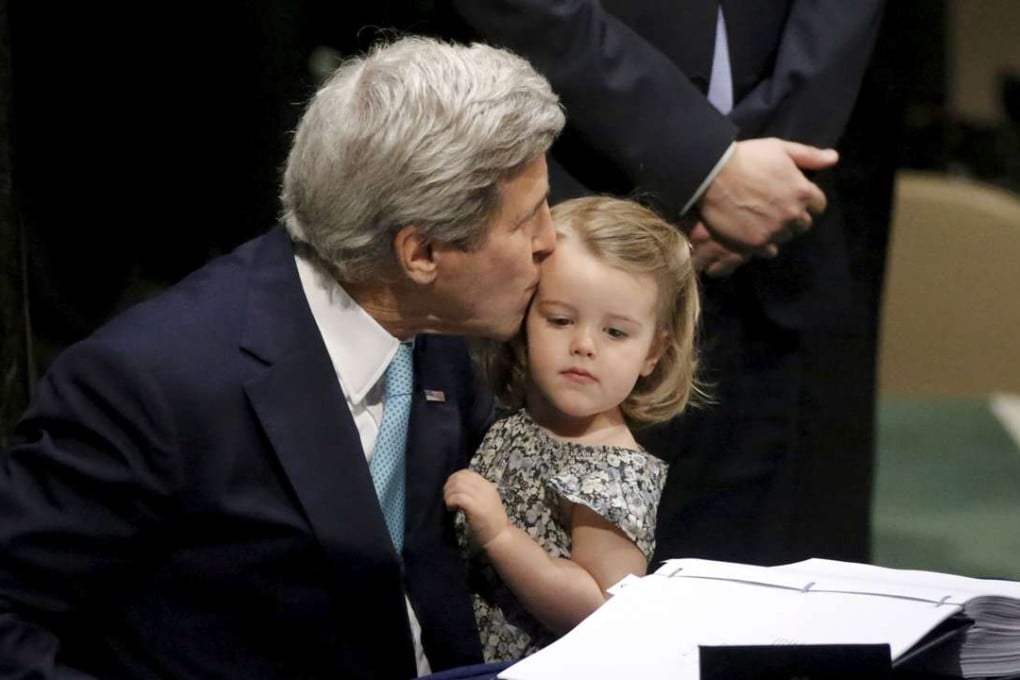 US Secretary of State John Kerry kisses his two-year-old granddaughter Isabelle Dobbs-Higginson after signing the Paris Agreement on climate change at United Nations Headquarters in Manhattan, New York. Photo: Reuters