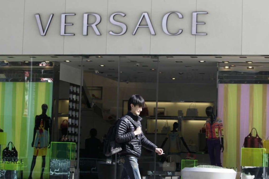 A pedestrian walks past a Versace store in Beijing. The Italian fashion brand will open its largest Asia store in Central, Hong Kong, in October. Photo: Reuters