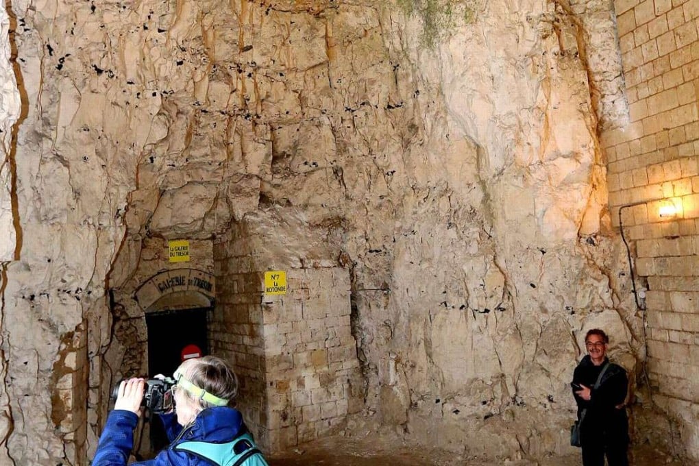 A tourist takes a picture inside the Naours underground "city" on April 21, 2016. Photo: AFP