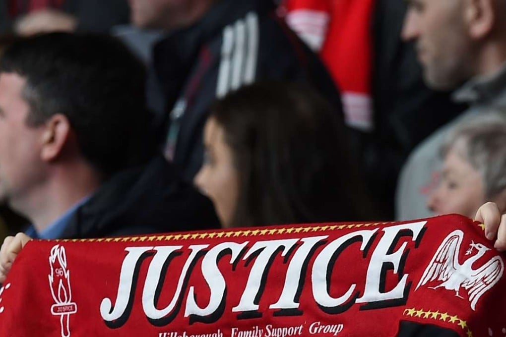 People hold football scarves during a memorial service at Anfield in Liverpool, north west Engand on April 15, 2016, on the 27th anniversary of the Hillsborough Disaster. 96 Liverpool supporters died at the 1989 FA Cup semi-final between Liverpool and Nottingham Forest at the Hillsborough football ground in Sheffield, northern England. Photo: AFP