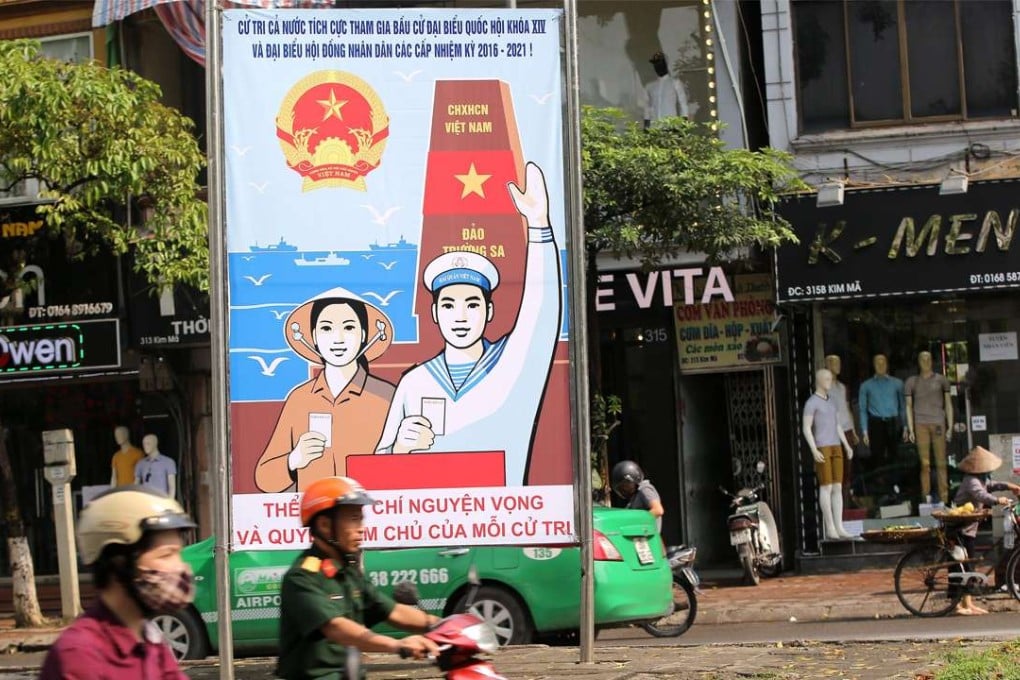 People ride past a poster reading ‘To elect shows the will, aspiration and benefit of each person’ for the upcoming elections at a street in Hanoi, Vietnam, 22 April 2016. Vietnam will hold legislative elections on 22 May 2016. Photo: EPA