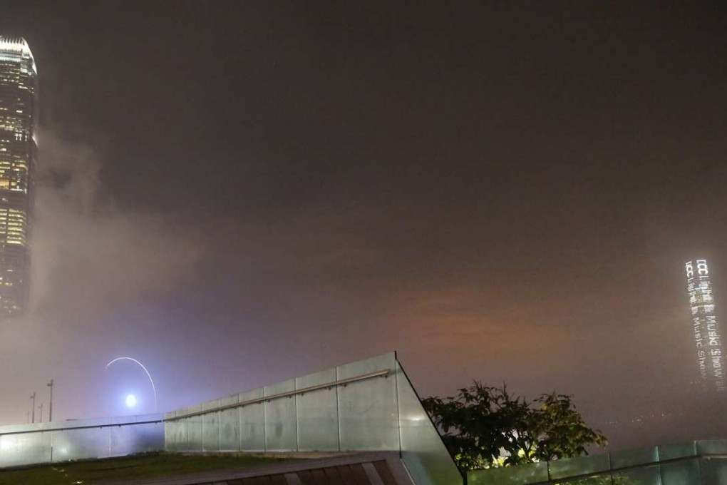 In this Wednesday, April 6, 2016 photo, a couple sit at a park against high-rise buildings which are partly covered by heavy fog alone Hong Kong's Victoria Harbour. Photo; AP, Vincent Yu