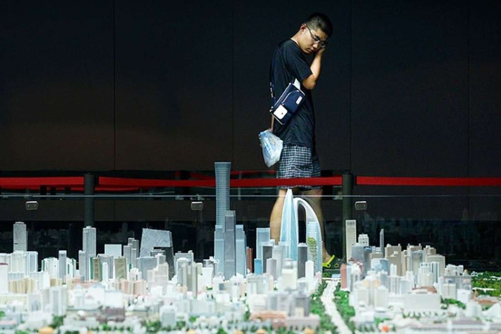 Provincial slowdowns may spur fresh questions over national expansion. Above, a visitor looks at a scale model of Beijing’s urban development at an exhibit in the capital. Photo: AFP
