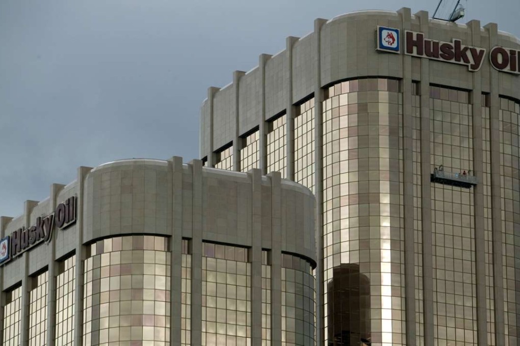 Window washers clean the Husky Oil Building in downtown Calgary. Photo; AFP, David Boily