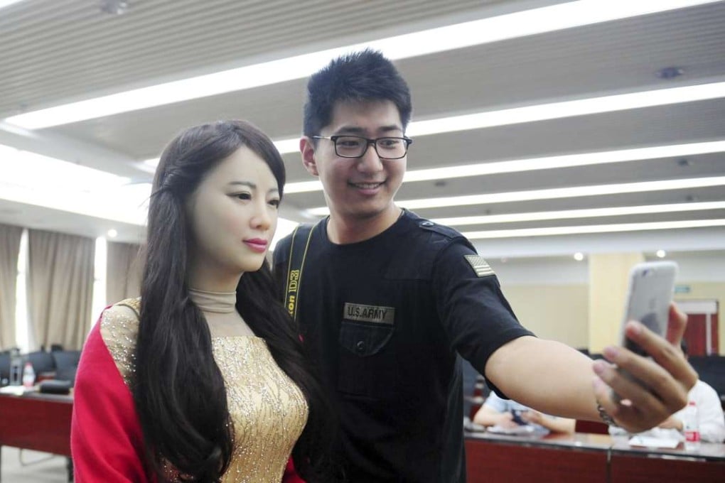 A man takes pictures with humanoid robot Jiajia produced by the University of Science and Technology of China. The Chinese government aims to bring research and development in China’s industrial robotics industry on a par with those in the West and Japan. Photo: Reuters