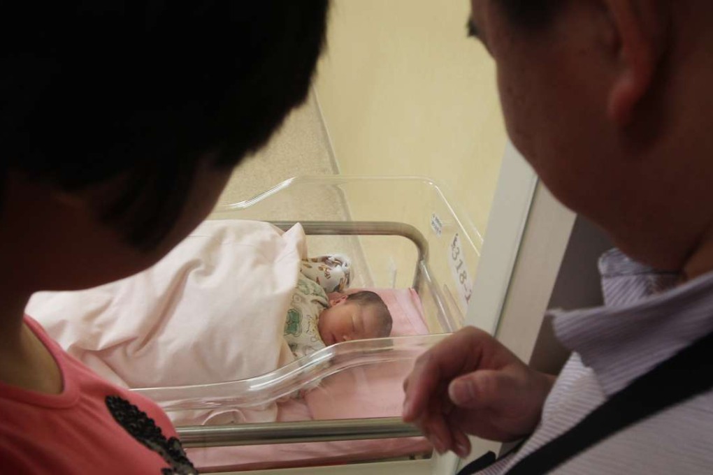 A pair of mainland couples from Dongguan surnamed watch their baby in St. Teresa's Hospital in Kowloon. Photo: Sam Tsang