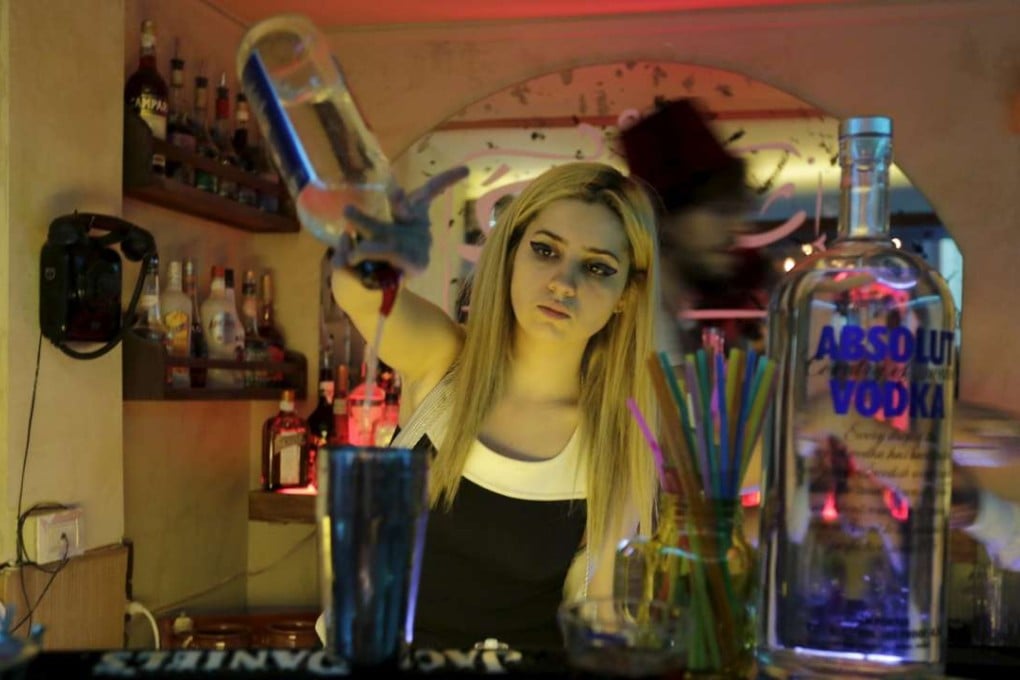 Dana Daqqaq, a bartender at Pub Sharqi, pours a drink during her shift in Damascus, Syria. Photo: Reuters