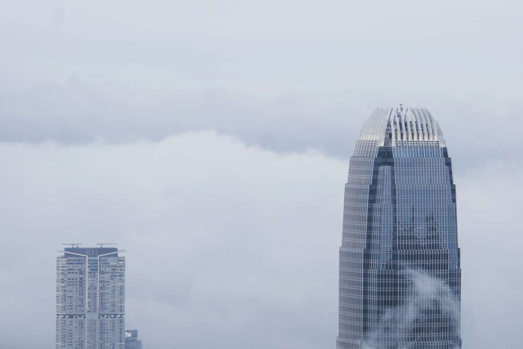 Two International Financial Center (IFC), right, stands shrouded in clouds in Hong Kong, China, as banking giant UBS warned of credit risks in financial markets in Hong Kong and other Chinese markets. Photo: Bloomberg