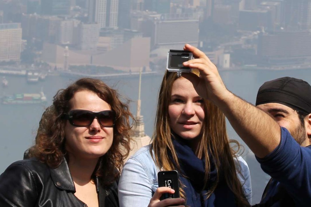 Tourists enjoy a fine day at the Peak Tower in Hong Kong. Photo: Dickson Lee