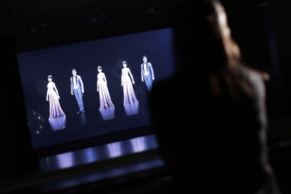 Mizuho Shinden watches a hologram of dancers with her face attached at the new Hologram Dance Theatre at Madame Tussauds in Tokyo. Photo: AP