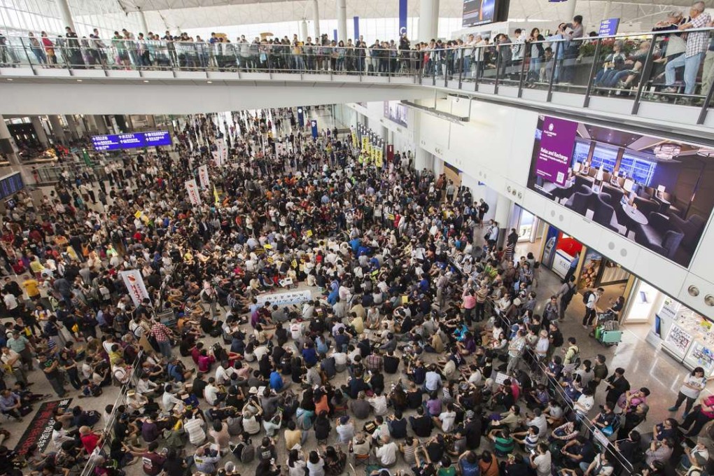 A large crowd stages a sit-in at Hong Kong International Airport after staff delivered the left luggage of the chief executive’s younger daughter to a restricted area, potentially compromising security. Photo: EPA