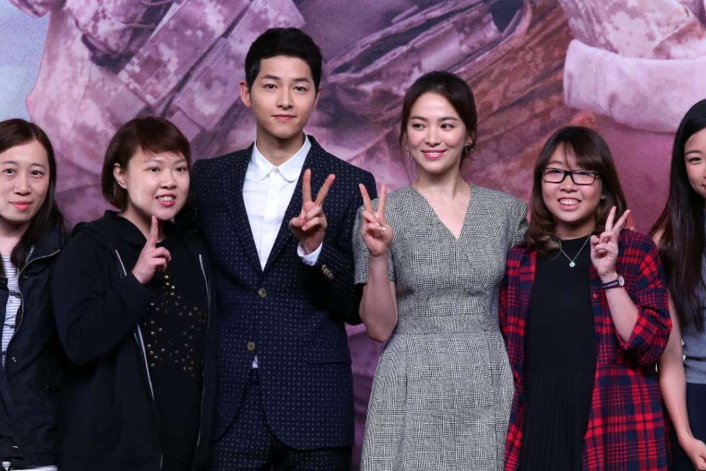 South Korean actor Song Joong-ki (L) with actress Song Hye-kyo from South Korean television series “Descendants of the Sun”, posing with their fans. Photo: SCMP Pictures