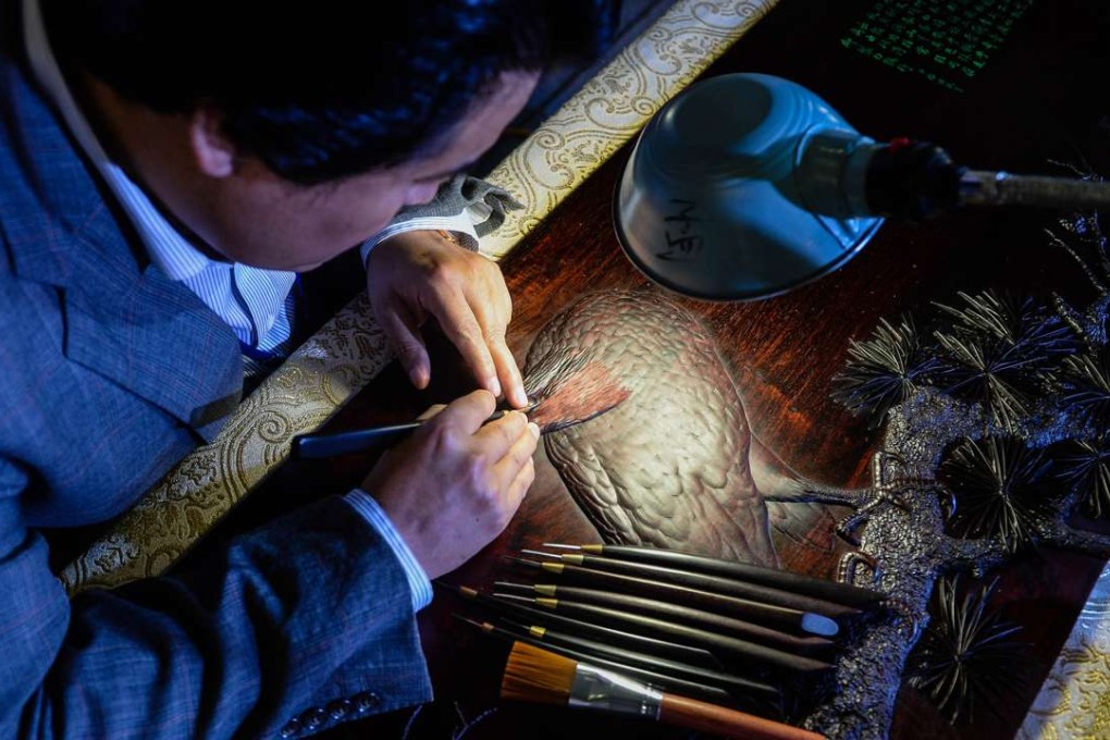 A wood carving art master makes a sandalwood carving in Wuxi, Jiangsu province. The fragrant tree is highly prized for furniture and incense wood. Photo: Xinhua