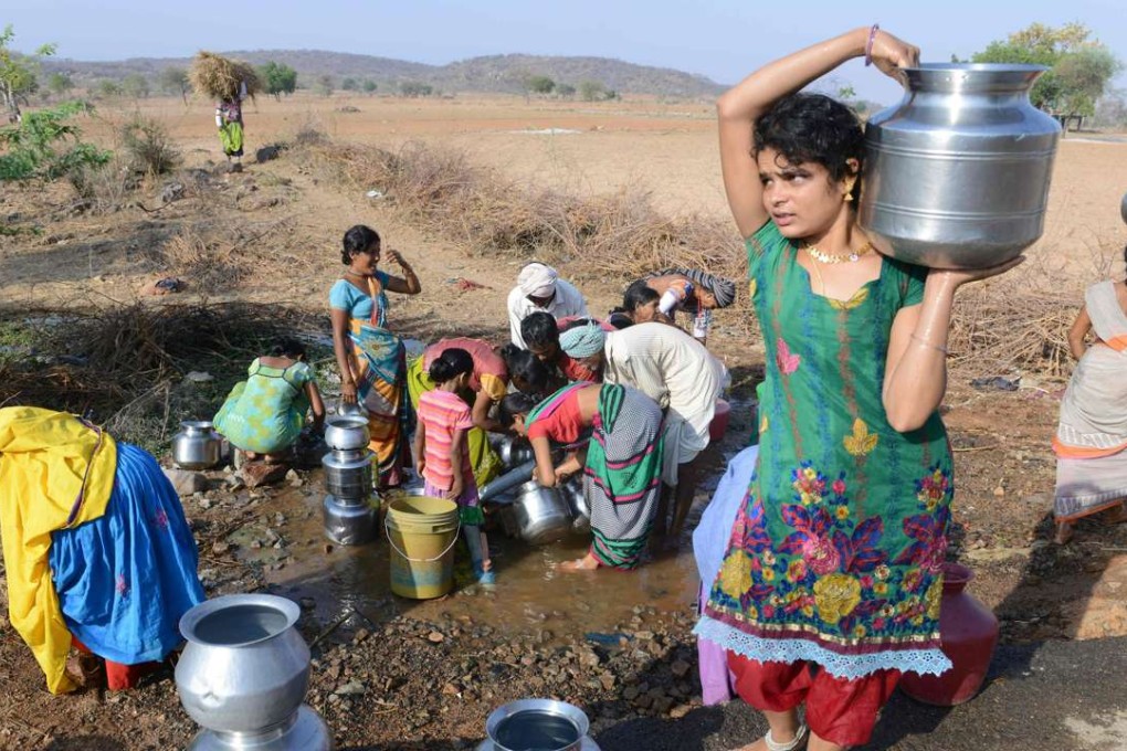 Indian Lambadi tribal villagers fill drinking water from a leaking pipe on a roadside at Chandampet Mandal in Nalgonda east of Hyderabad in the southern Indian state of Telangana. Photo: AFP