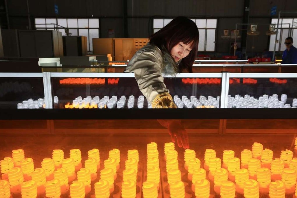 A woman works on a production line for energy-saving lamps in a factory in Suining in southwest China's Sichuan province. Photo: EPA