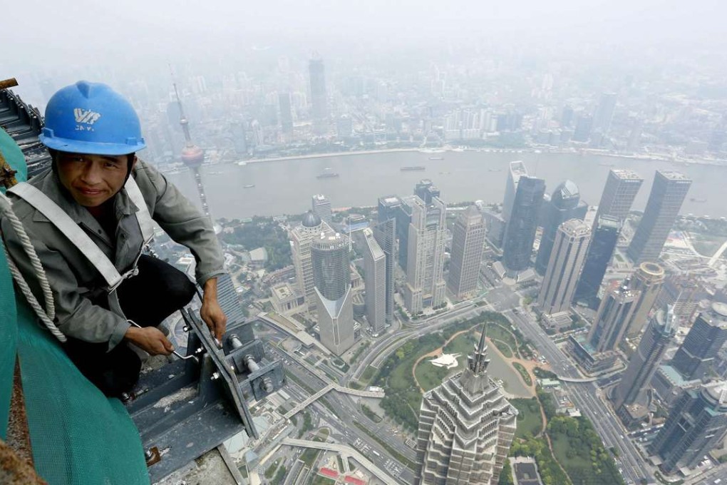 A labourer atop the Shanghai Tower at the financial district of Pudong in Shanghai. Photo: Reuters