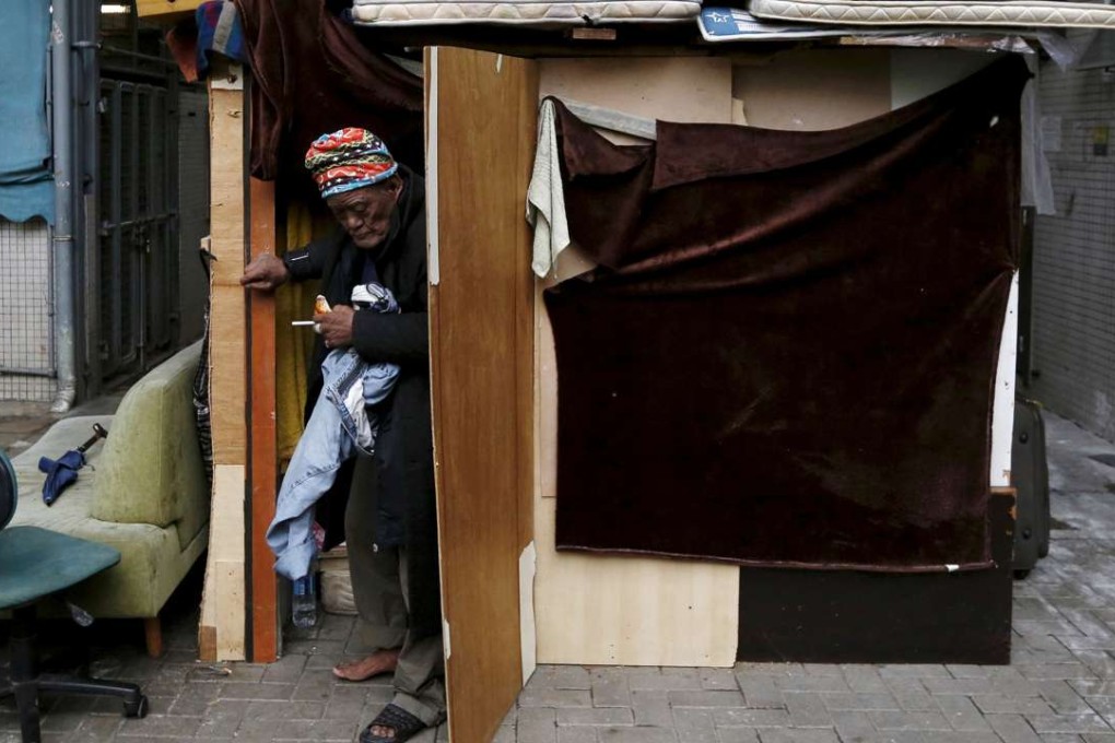A man who sleeps on the street walks out of his makeshift home under a bridge at a residential area in Hong Kong. Photo: Reuters.