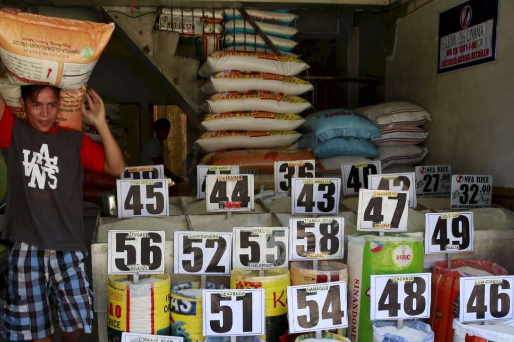 A worker carrying a sack of rice walks past a rice store in Manila September 9, 2015. Photo: Reuters